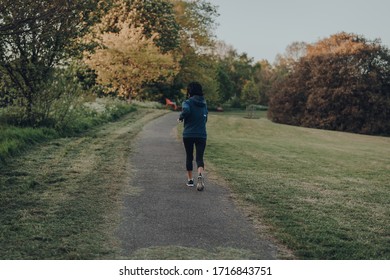 London, UK - March 22, 2020: Rear View Of A Woman Running Alone In Broomfield Park, Public Park In Palmers Green In The London Borough Of Enfield, UK.