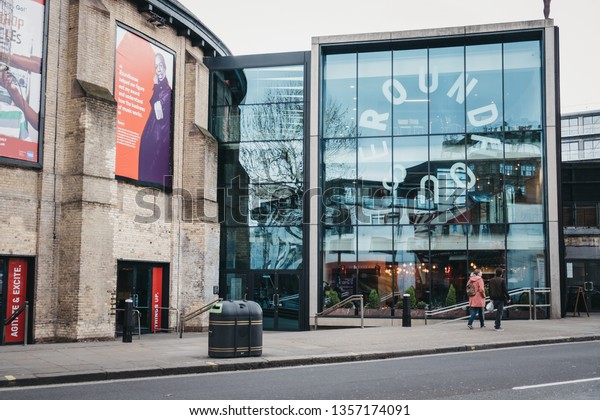 London, UK - March 23, 2019: People walking past The\
Roundhouse, a performing arts and concert venue situated at the\
Grade II listed former railway engine shed in Chalk Farm, London,\
UK.
