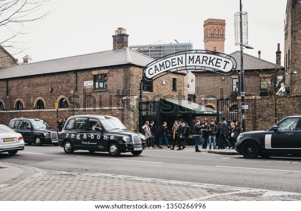 London, UK - March\
23,2019: Taxis and people in front of Camden Market. Started with\
16 stalls in March 1974, Camden Market is one of the busiest retail\
destinations in London.