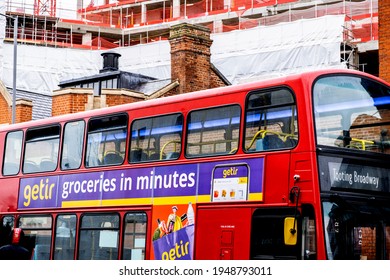 London UK, March 26 2021, Red Double Decker Bus Passing Through A Town Centre Close Up With No People