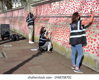 London, UK - March 30, 2021: The National Covid Memorial Wall, Volunteers Painting 150,000 Red Hearts To Commemorate Covid-19 Deaths