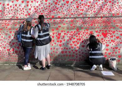 London, UK - March 30, 2021: The National Covid Memorial Wall, Volunteers Painting 150,000 Red Hearts To Commemorate Covid-19 Deaths