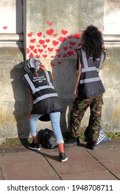 London, UK - March 30, 2021: The National Covid Memorial Wall, Volunteers Painting 150,000 Red Hearts To Commemorate Covid-19 Deaths