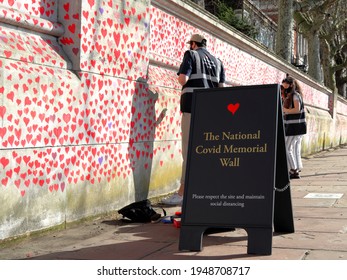 London, UK - March 30, 2021: The National Covid Memorial Wall, Volunteers Painting 150,000 Red Hearts To Commemorate Covid-19 Deaths