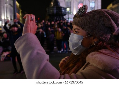 LONDON, UK - MARCH 7 2020: Tourists In Piccadilly Circus, London Wear Facemasks As Coronavirus - Or Covid-19 - Spreads Around The World. 