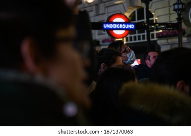 LONDON, UK - MARCH 7 2020: Tourists In Piccadilly Circus, London Wear Facemasks As Coronavirus - Or Covid-19 - Spreads Around The World. 