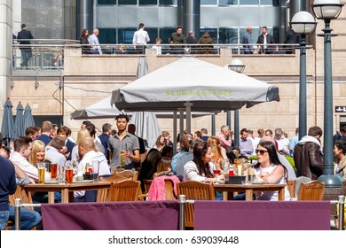 London, UK - May 10, 2017 - An Outdoor Bar In Canary Wharf Packed With People Drinking On A Sunny Day