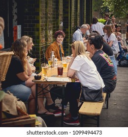 London, UK - May, 2018. A Group Of Young People Having Drinks Outside A Pub Near Columbia Road In Shoreditch. 