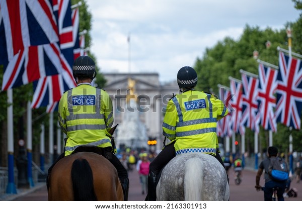 LONDON, UK - May 29, 2022: Two Mounted Police\
Officers Ride down The Mall, London,\
UK