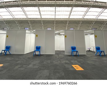 London, UK - May 6th 2021: People social distance whilst waiting at a Covid 19 Coronavirus vaccination centre in central London to get the Moderna vaccine at the Business Design Centre