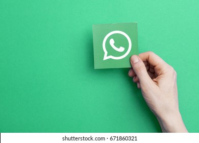 LONDON, UK - May 7th 2017: Hand holding WhatsApp logo. WhatsApp is a popular social media application for sharing messages, images and videos