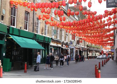 London / UK - May 8 2020: People Queuing Outside A Chinese Supermarket In Lisle Street, Chinatown In Central London During Covid 19 Lockdown