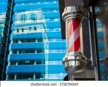 London, UK. May 9th 2020: An East London Barber Shop Pole In Red & White Spiral Stripes. Hair-cut, Hair Dresser, Grooming Service, Advertising Sign, Coronavirus, Covid-19, Lockdown.