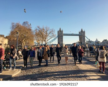 London, UK - Nov 2016: Crowd Of People Walking By Tower Of London And Thames River In Sunny Morning With Tower Bridge In Background. Clear Blue Sky. Gulls Flying In Sky.