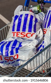 London, UK, November 19, 2011 : Customer shopper pushing a shopping trolley cart full of plastic carrier bags at its Tesco Extra supermarket retail business store in Brent Park Wembley stock photo