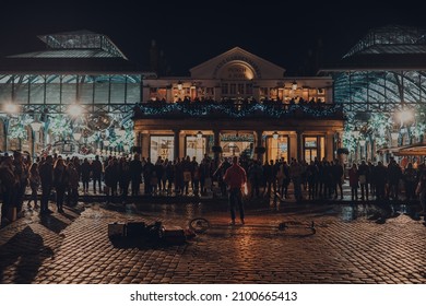 London, UK - November 23, 2021: Street Performance In Front Of A Crowd Next To Covent Garden Market, One Of The Most Popular Tourist Sites In London, On A Cold Winter Evening.