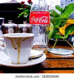 London UK, October 06 2020, Cup Of Espresso Coffee With A Jug Of Water And An Empty Bottle Of Coca-Cola Drink On A Table Top Setting With No People