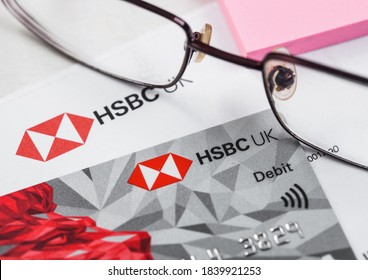 LONDON, UK - OCTOBER 14, 2020: HSBC UK Bank Debit Card With Glasses And Blue Pen On Bank Statement Paperwork.