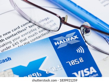 LONDON, UK - OCTOBER 14, 2020: Halifax Bank Debit Card With Glasses And Blue Pen On Bank Statement Paperwork.