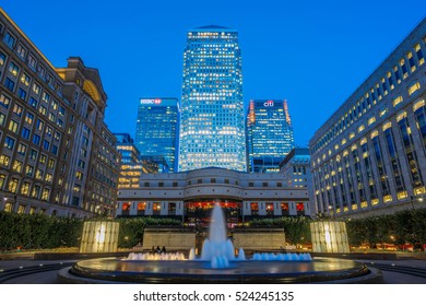 London, UK - October 20, 2016 - People hanging around Cabot Square in Canary Wharf with illuminated One Canada Square building in the background