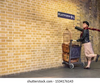 London, UK - October 2019: Harry Potter Fan At Kings Cross Station Taking Pictures At ‘Platform 9 3/4’