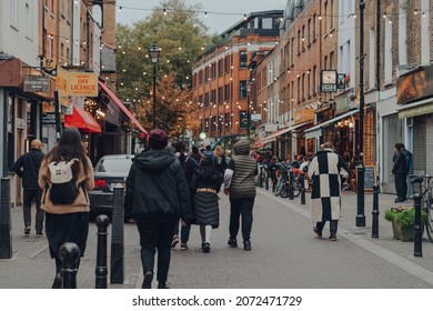 London, UK - October 23, 2021: Rear view of people walking in Exmouth Market, a semi-pedestrianised street in Clerkenwell, Islington, and a famous street market.