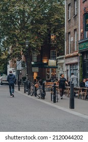 London, UK - October 23, 2021: Bikes parked in Exmouth Market, a semi-pedestrianised street in Clerkenwell, Islington, and a famous street market. People walking past, city life concept.