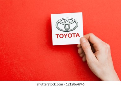 LONDON, UK - October 26th 2018: Hand holding a Toyota logo. Toyota is an automobile manufacturer.