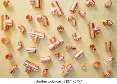 LONDON, UK – OCTOBER 4, 2021: Concept for plumbing - various copper fittings and adapters in flat lay - elbows, tees, cap, reducers, coupling