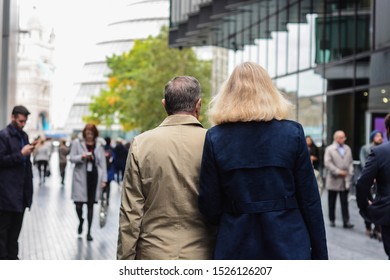 London, UK, October 8, 2019: Middle Age Couple, Elegant And Casual Is Walking In Business Area Near Tower Bridge 