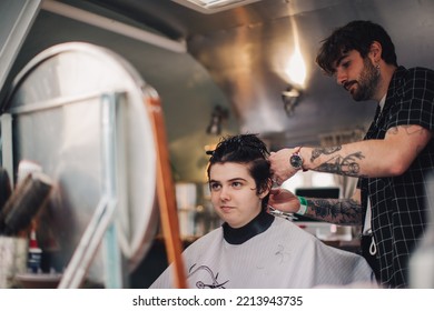 London UK - October 9, 2021: Hairstylist Doing Haircut In Mobile Hair Salon At Classic Car Boot Sale, A Retro Culture Festival.