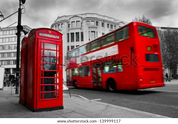 London, the UK. Red phone booth and red bus in\
motion. English icons