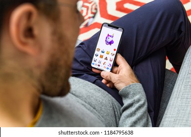 LONDON, UK - SEP 21, 2018: Man Using The New AR Memoji Emoji On Apple IPhone Xs With The Immense OLED Retina Display And A12 Bionic Chip, With The Face Of Smiling Unicorn