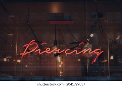 London, UK - September 03, 2021: Piercing Neon Sign In A Window Of Rachels Salon In East End Of London, A Trendy Area That Is Home To An Array Of Markets, Bars And Restaurants.