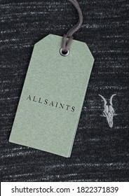 LONDON, UK - SEPTEMBER 09, 2020: ALLSAINTS Logo And Clothing Tag On Grey Cotton Fabric.