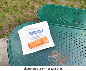 London, UK - September 10, 2020: Greggs Sausage Roll Shot Outside In A Park Laying On A Green Picnic Table