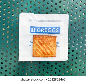 London, UK - September 10, 2020: Flat Lay Of Greggs Steak Bake Resting On Blue And White Branded Paper Bag