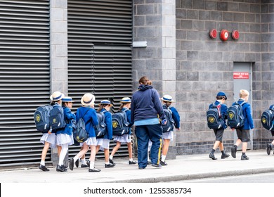 London, UK - September 12, 2018: Group Of Many School Children On Field Trip Walking On Sidewalk Street With Uniforms, Backpacks And Teachers Guardians In Westminster, Pimlico