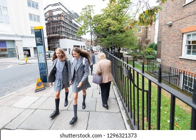 London, UK - September 12, 2018: Two Girls School Children Walking On Sidewalk Street With Uniforms In Westminster Urban Area