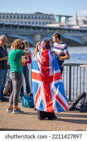 London, UK - September 14, 2022: A Woman Waiting In Line To See The Queen Lying In State, With A Union Jack Flag Wrapped Around Her