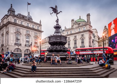 LONDON, UK - SEPTEMBER 15, 2018: The historic architecture of London in the United Kingdom at sunset showcasing Piccadilly Circus with lots of locals and tourists passing by.