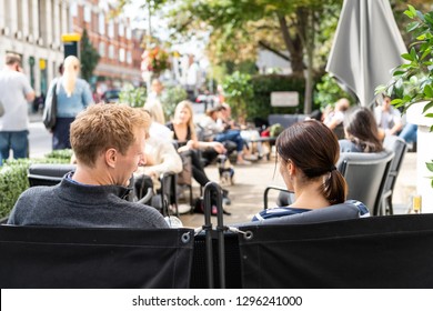 London, UK - September 16, 2018: Man And Woman Young Couple Sitting Outside At Cafe Table In Chelsea Outdoor Restaurant Street Sidewalk At Joe And The Juice