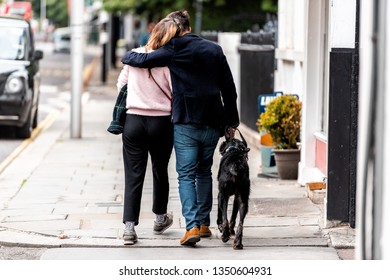 London, UK - September 16, 2018: Neighborhood District Of Chelsea And Brompton In Kensington With Couple Walking On Sidewalk Pavement Embracing Romantic With Dog