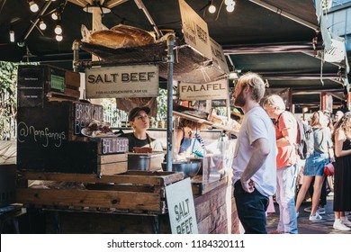 London, UK - September 17, 2018: Man buying salt beef sandwich from Nana Fanny's market stand in Borough Market, one of the largest and oldest food markets in London.