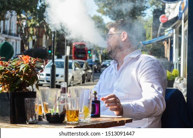 London, UK, September 19, 2019: Middle Age Man Smoking A Electronic Cigarette At The Outside Table Of A Pub