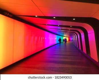 London / UK - September 2020: Colourful pedestrian tunnel at King's Cross Station in London. You can see shapes of people far away at the other end of the tunnel.