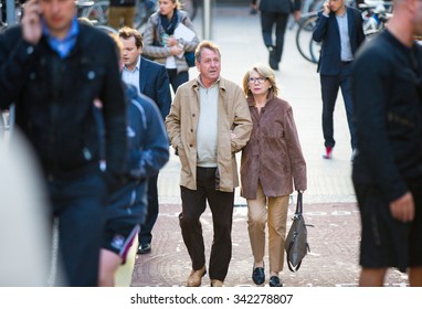 LONDON, UK - SEPTEMBER 9, 2015: Mature Age Couple Passing Bridge In Canary Wharf. 