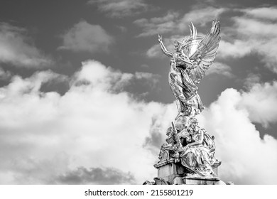 London, UK: Victory Goddess golden statue on top of the Victoria Memorial located in front of the Buckingham Palace; outdoor goddess statue in black and white