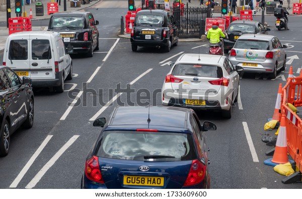 London. UK-05.16.2020: commuters in cars,\
motorcycles and London Black Cab on Camden High Street. Commuters\
are urged to avoid public transport in fear of overcrowding facing\
Covid-19 pandemic.