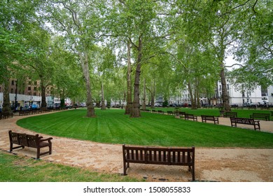 London, United Kingdom - 2019: Berkeley Square, spring, green trees and grass, empty banches.